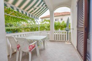 a patio with a table and chairs on a balcony at Apartments Promina in Biograd na Moru