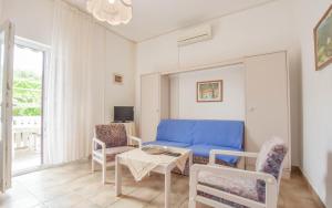 a living room with a blue couch and chairs at Apartments Promina in Biograd na Moru