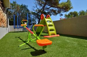 a playground with a green and orange play equipment at Villa Korcula in Prizba