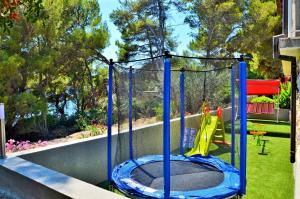a trampoline in a backyard with a playground at Villa Korcula in Prizba