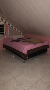 Manate hebergement في فا: سرير كبير في غرفة بجدران وردية