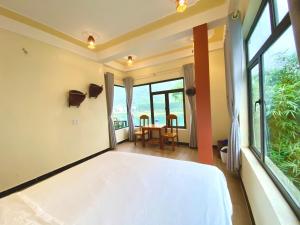 峰牙的住宿－Phong Nha Coco Riverside，一间卧室配有一张床和一张桌子及椅子