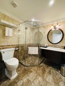 a bathroom with a toilet and a shower and a sink at Hotel du Monde in Hanoi