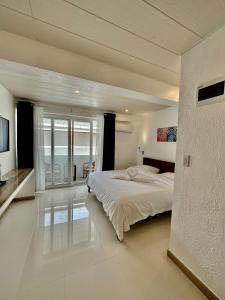 a bedroom with a large bed and a large window at Calypso Beach and Dive Resort in Boracay