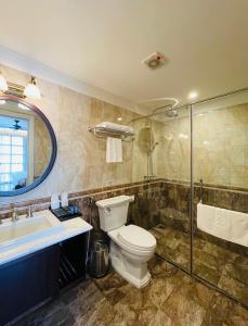 a bathroom with a toilet and a sink and a shower at Hotel du Monde in Hanoi