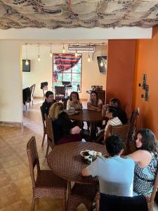 Tawaca ecohotel في سانتا مارتا: مجموعة من الناس يجلسون على طاولة في مطعم