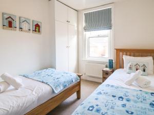 une chambre avec deux lits et une fenêtre dans l'établissement South Harbour Cottage, à Weymouth