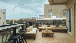 a balcony with couches and tables on a building at 龍家民宿 The Laid-back Dragon Lodge in Magong