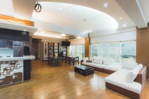 a living room with white couches and a kitchen at 龍家民宿 The Laid-back Dragon Lodge in Magong