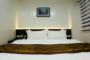 een slaapkamer met een groot bed met witte lakens en kussens bij PRIMELUXE HOTEL in Cagayan de Oro