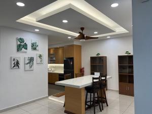 cocina con ventilador de techo y encimera con taburetes en 3 bedrooms (private bathroom) Perdana Hill Villa en Lahad Datu