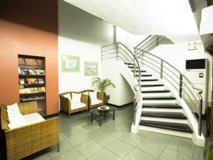 a lobby with a spiral staircase and chairs at Harbor Town Hotel in Iloilo City