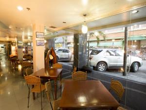 a restaurant with tables and chairs and a car in the window at Harbor Town Hotel in Iloilo City