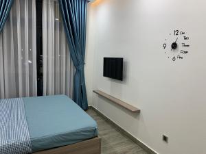 a bedroom with a bed and a clock on the wall at Liên’s Mini Hotel in Phú Quốc