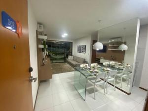 uma sala de jantar com uma mesa de vidro e um sofá em Iloa Residence Luxo na Barra de São Miguel