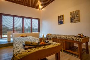 um quarto com duas camas e uma mesa em Budhi Ayu Villas and Cottages Ubud by Mahaputra-CHSE Certified em Ubud