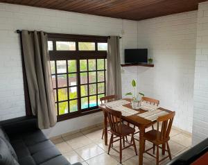 プライア・ド・ローザにあるPousada Uluwatu, Praia do Rosaのテーブルと窓のあるダイニングルーム