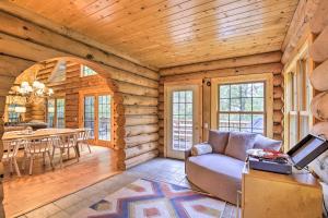 a living room and dining room in a log cabin at Splendid Family Cabin with Hot Tub and Grill! in Lake City