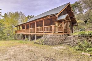 a large log cabin with a porch and stairs at Splendid Family Cabin with Hot Tub and Grill! in Lake City