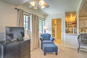 a living room with a tv and a blue chair at Peaceful Prescott Studio with Mountain Views! in Prescott