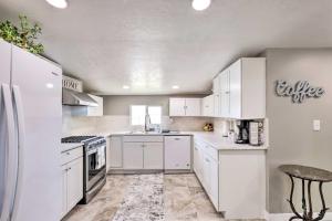 a kitchen with white cabinets and a white refrigerator at Cozy Magna Apartment - Near Parks and Lakes! in West Valley City