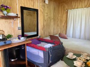 a room with a bed with a suitcase on the floor at Cabaña Lemupewen Chillán 6 in Chillán