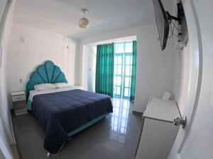 Una cama o camas en una habitación de AQUAMARINE PARACAS Beach Hostal