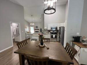 a kitchen with a wooden table with a vase of flowers on it at Mid City Condo in Huntsville