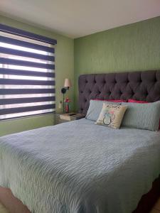 a bedroom with a large bed with a large headboard at Luxury departament Centenario in Guadalajara
