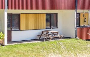 una mesa de picnic junto a un edificio con una pared amarilla y roja en Cozy Apartment In Paulistrm With Kitchen en Pauliström