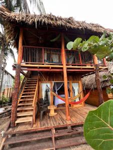 een huis met een rieten dak en een stoel aan de voorkant bij Coco Lodge, vista al mar in La Poza