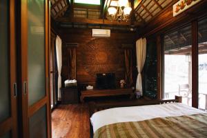 a bedroom with a bed and a chandelier at Baansuwanburi in Chiang Mai