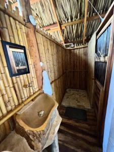 een badkamer met een bad in een rieten gebouw bij Coco Lodge, vista al mar in La Poza
