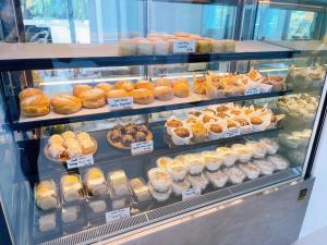 a display case filled with different types of pastries at The Corner มุมม่วน คาเฟ่ แอนด์ โฮสเทล MumMuan hostel in Chiang Mai