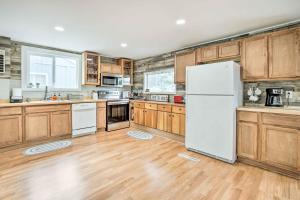 a kitchen with wooden cabinets and a white refrigerator at Historic Casper Retreat with Renovated Yard! in Casper