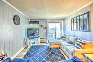sala de estar con sofá y TV en Myrtle Beach Condo with Balcony Walk to Beach!, en Myrtle Beach