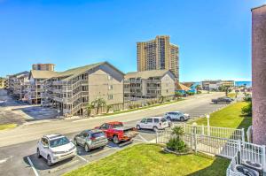 eine Apartmentanlage mit Autos auf einem Parkplatz in der Unterkunft Myrtle Beach Condo with Balcony Walk to Beach! in Myrtle Beach
