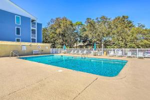 a swimming pool in front of a building at Myrtle Beach Condo with Balcony Walk to Beach! in Myrtle Beach