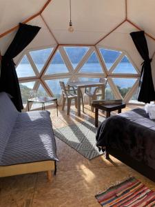 a room with a bed and tables in a tent at Glamping Vista Lago Guatavita in Guatavita