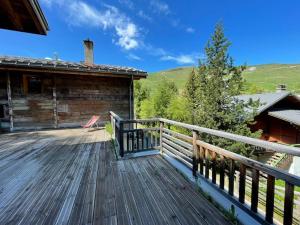 a deck of a cabin with a wooden railing at Appartement 4 chambres avec grande terrasse in Les Deux Alpes