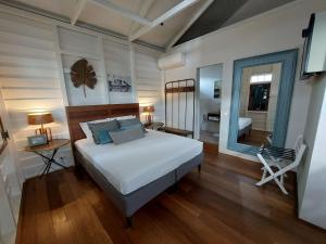 a bedroom with a bed and a table and a chair at Couleur Locale Paramaribo in Paramaribo
