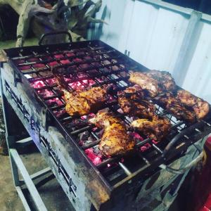 a grill with chickens and meat cooking on it at Palliyadiyil Homestay in Thekkady +40 photos