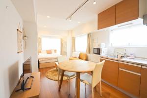a kitchen and a dining room with a table and a room with a bed at Shibuya Park Residence Yoyogi Park in Tokyo