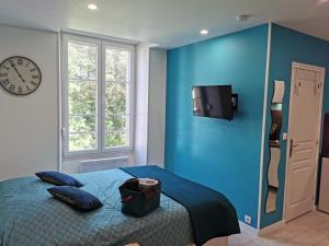 a blue bedroom with a bed and a refrigerator at VITTEL LOC'S - LE 147 - Studio classé 2 étoiles CALME ET COSY in Vittel
