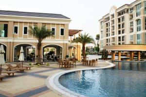 a resort with a swimming pool and tables and buildings at LK Legend in Pattaya