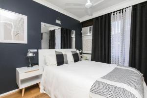 a bedroom with a white bed and blue walls at Modern Apartment Close to the City Centre 16 in Cairns