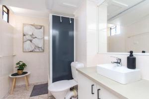 a bathroom with a white toilet and a sink at Modern Apartment Close to the City Centre 16 in Cairns