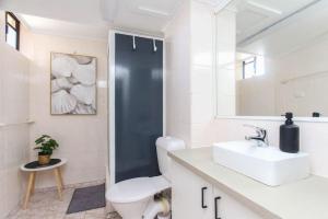 ein Badezimmer mit einer weißen Toilette und einem Waschbecken in der Unterkunft Modern Apartment Close to the City Centre 16 in Cairns