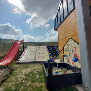 a playground with a slide next to a building at Wild nest Deer Lux in Zlatibor