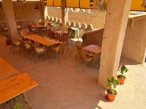 an overhead view of a restaurant with wooden tables and chairs at Bait Aljabal Hospitality Inn in Al Ḩamrāʼ